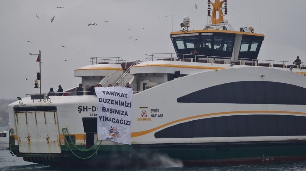 Kadınlar denizin ortasında pankart a&ccedil;tı: 'Tarikat d&uuml;zeninizi başınıza yıkacağız!'